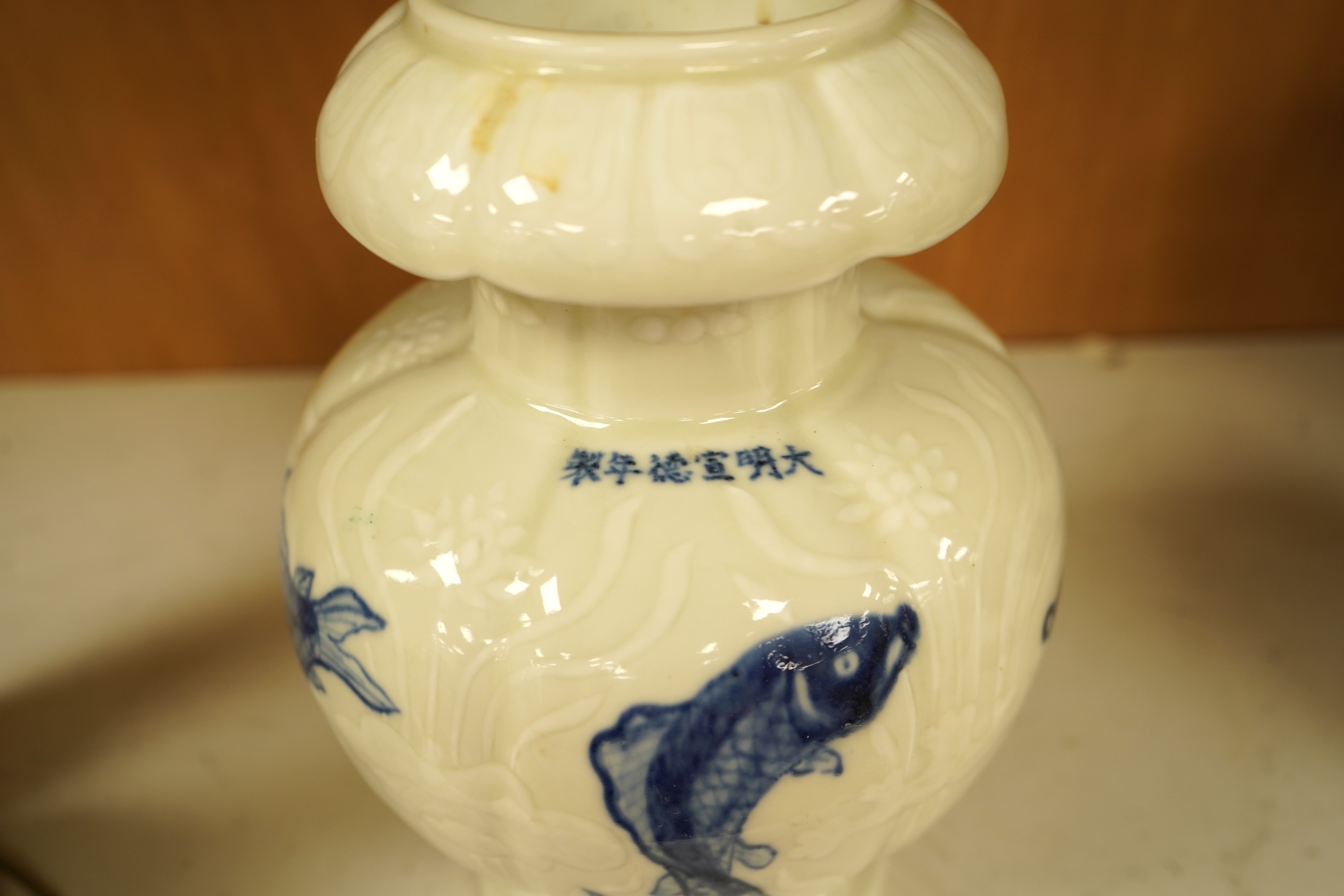 A Chinese vase decorated in low relief, hand painted with fish, 20cm high